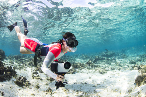 woman snorkeling in ocean with iPhone 7 water housing and pistol grip